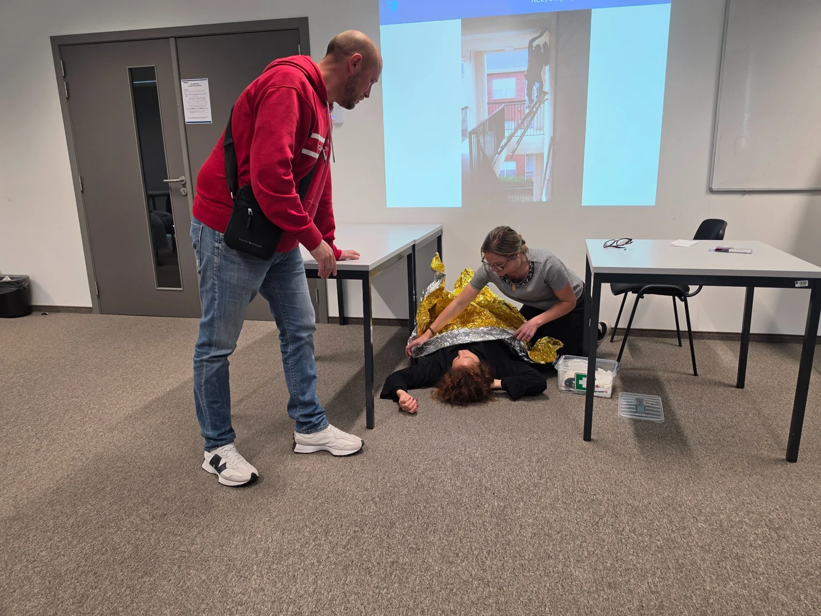 Un formateur accompagne un exercice avec une victime simulée
